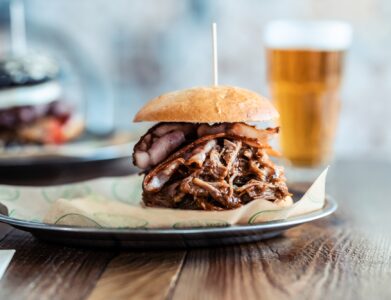 Delicious fresh homemade big burguer on a rustic wooden table in the restaurant.