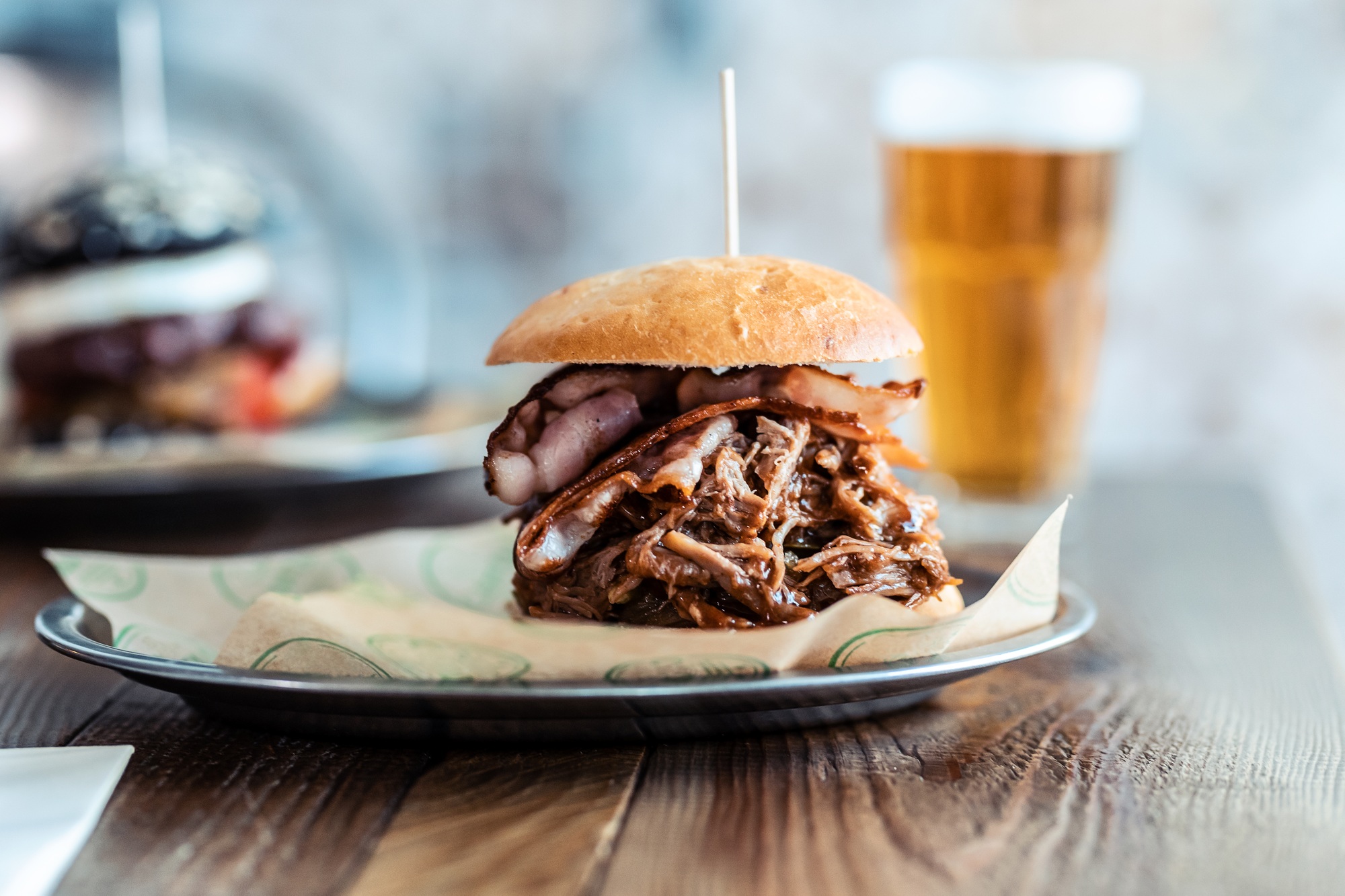 Delicious fresh homemade big burguer on a rustic wooden table in the restaurant.